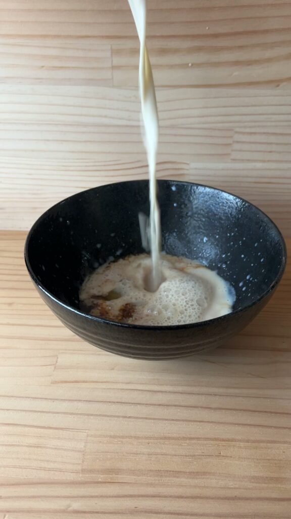 温めた豆漿を高いところから器に一気に注いでいるところ