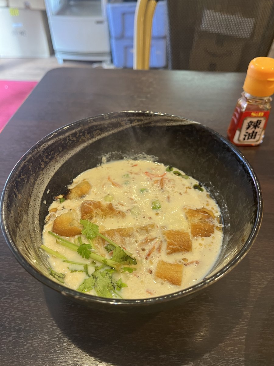 浅草豆花大王の鹹豆漿(シェントウジャン)。黒い器に湯気の立つ豆乳スープ、パクチーと揚げパンがのっている