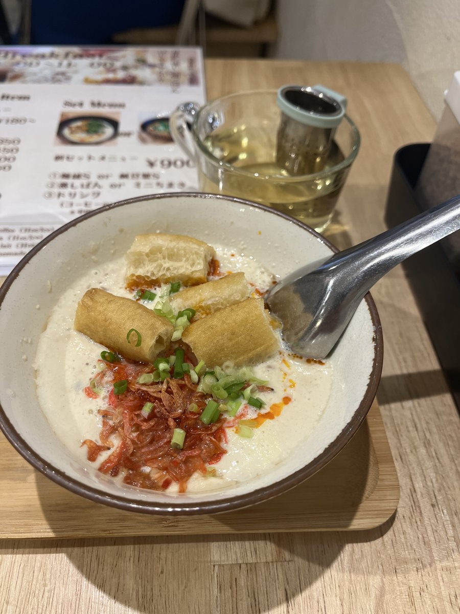 白い器に入ったシェントウジャン。白い豆乳の上に、赤いエビ、刻んだねぎ、揚げパンがのり、表面にラー油が浮いている