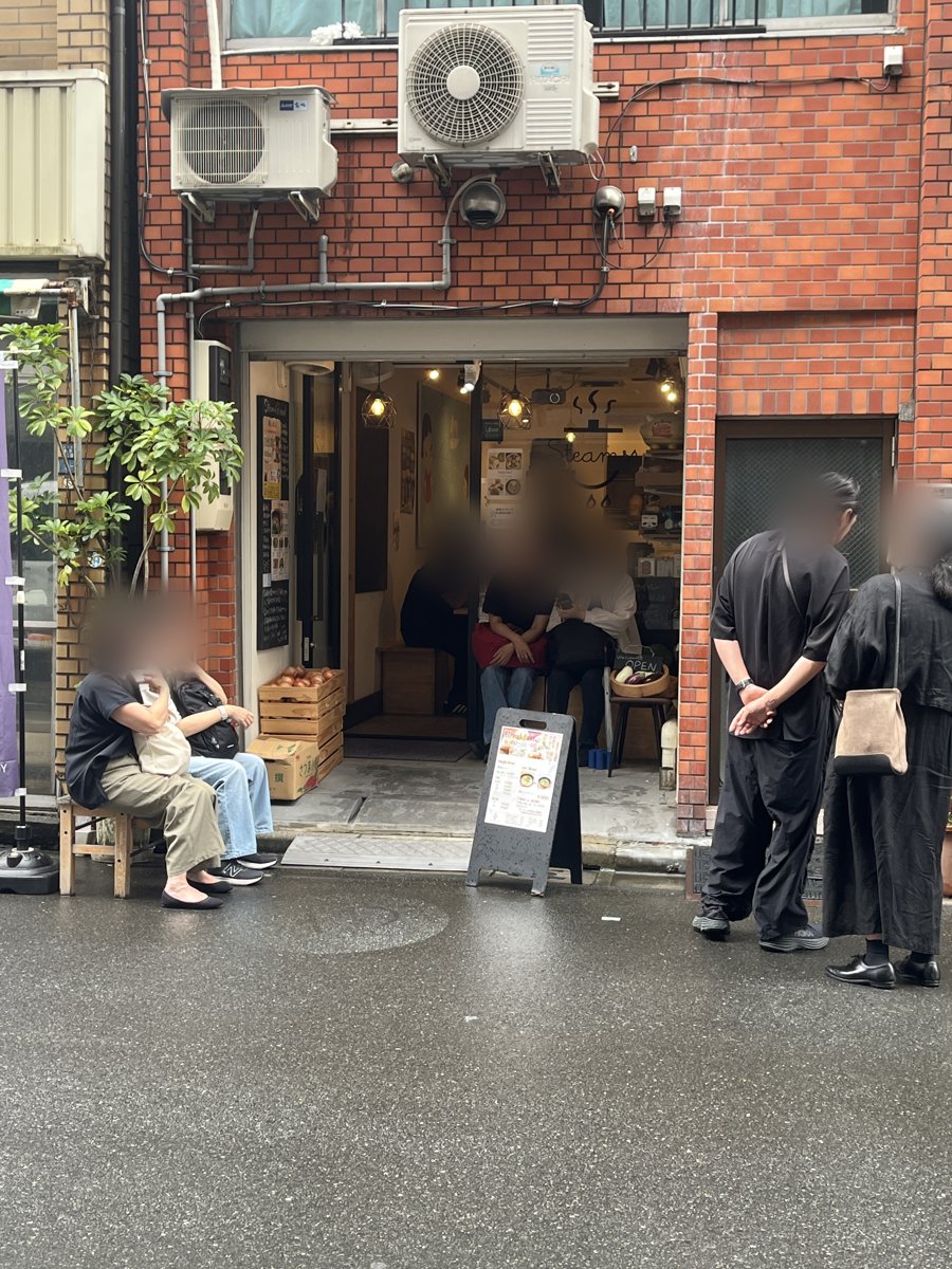 Steamsの店頭。れんが造りの建物の1階にガラス戸の入口があり、入口の前に朝食メニューの立て看板が出ている
