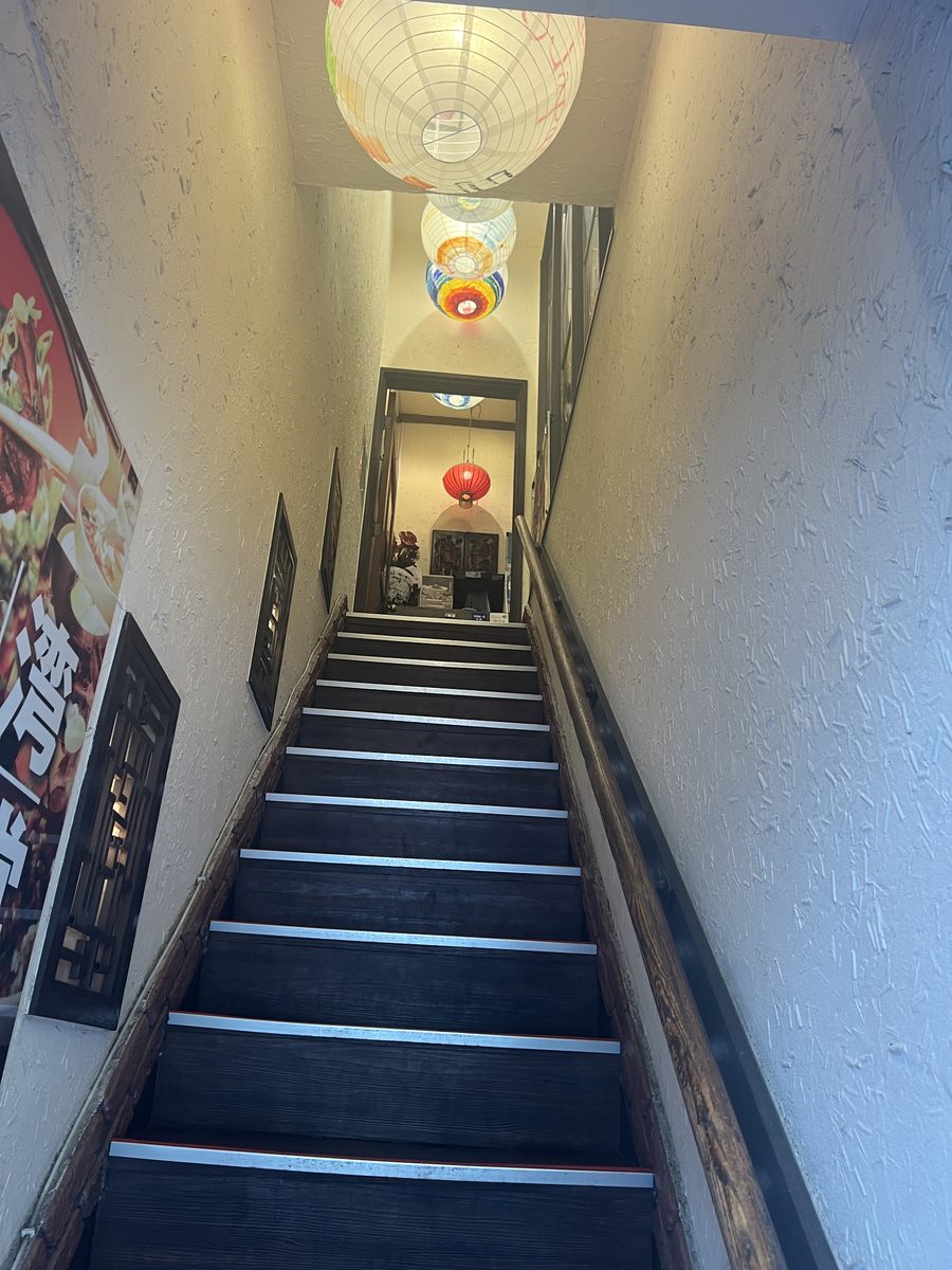 2階のお店へ上がる階段。上のほうにランタンが下がっている