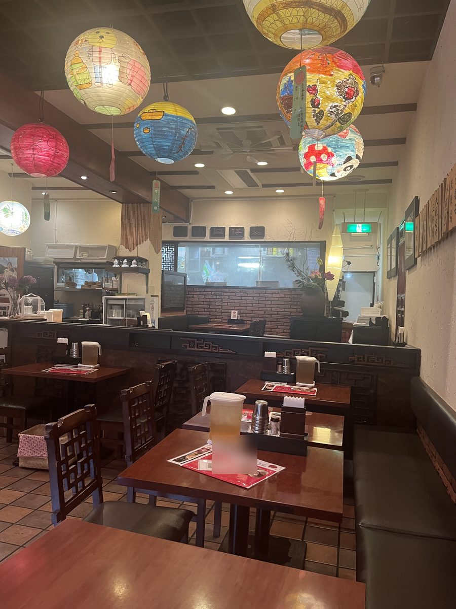 店内。色とりどりのランタンが天井から下がり、奥に厨房が見える