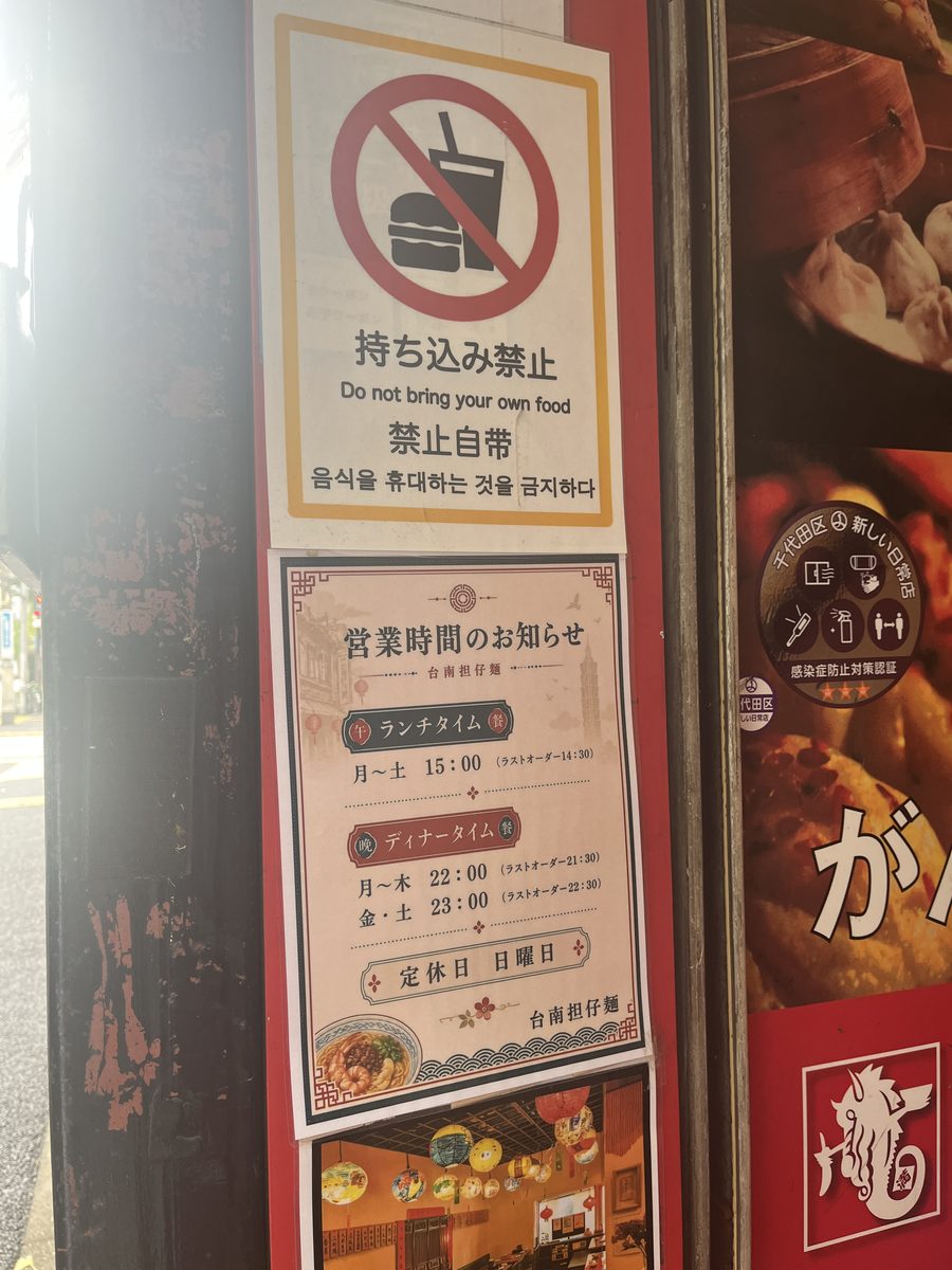 台南担仔麺 水道橋本店の店頭の掲示。営業時間のお知らせと、定休日は日曜日