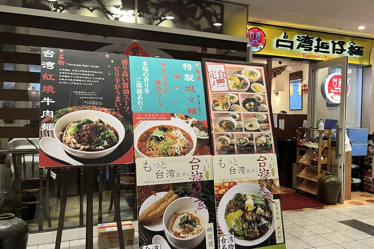 台湾担仔麺 汐留店の店頭。黄色い看板と、定食メニューの立て看板が並んでいる